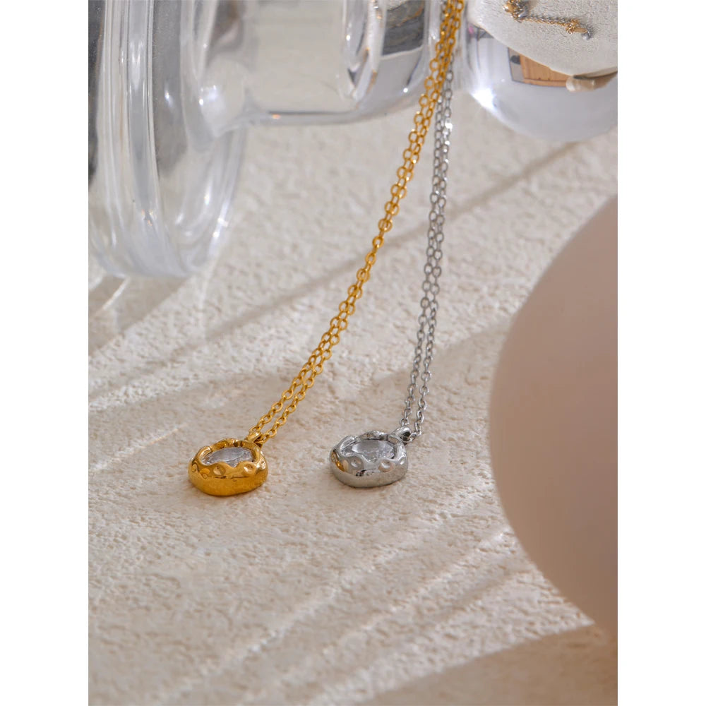 Colares femininos delicados dourado e prateado com pingente circular moderno sobre superfície clara